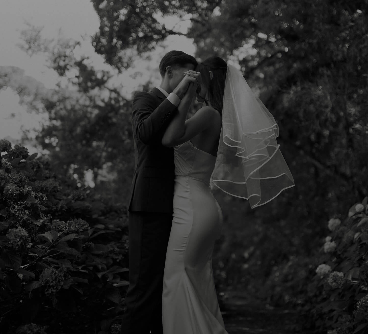 Сouple wearing a white gown and a black suit. Mobile image